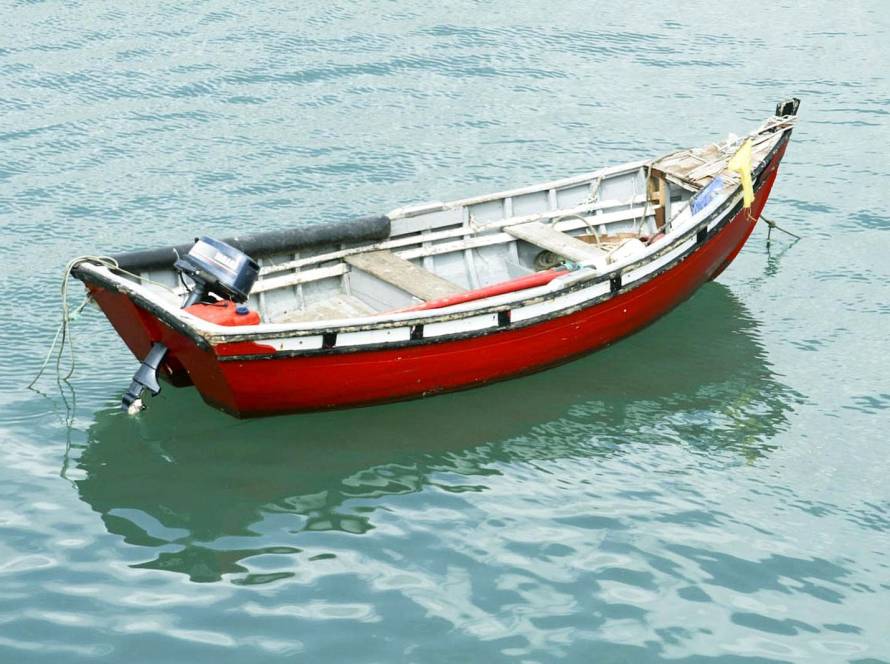 Little red boat on blue-green water