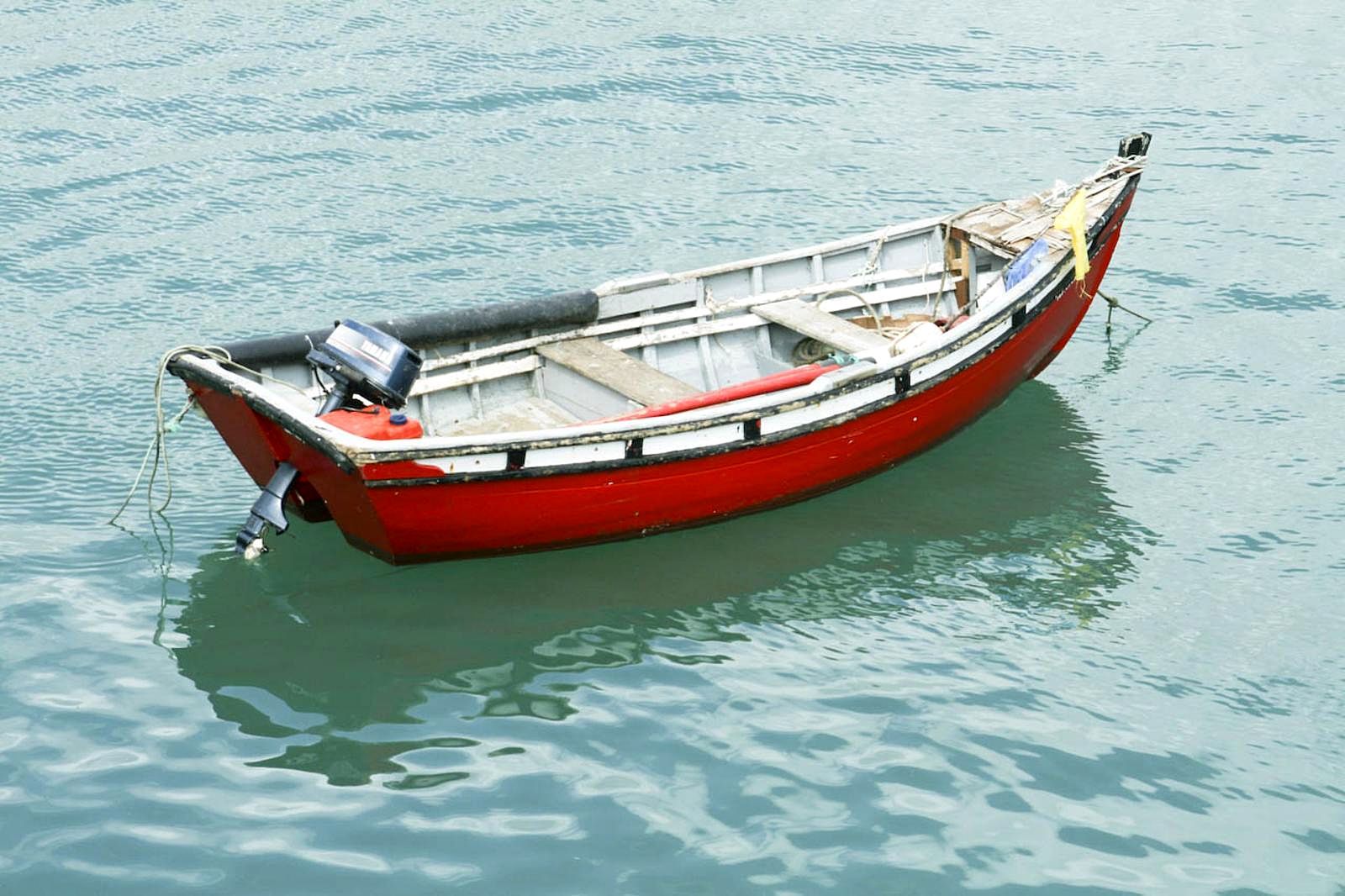 Little red boat on blue-green water