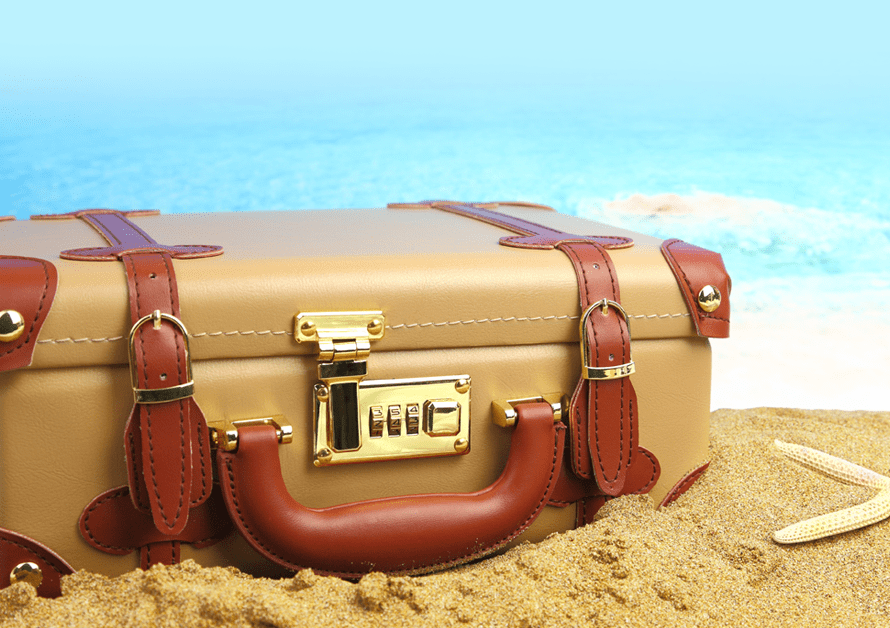 vacation_suitcase on sand beside water