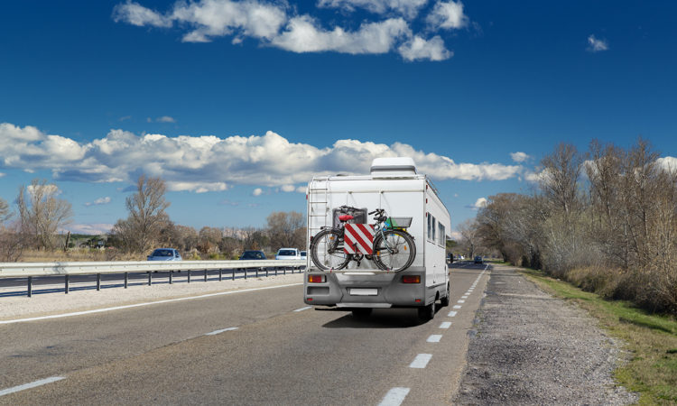RV traveling to campground on 4-lane highway