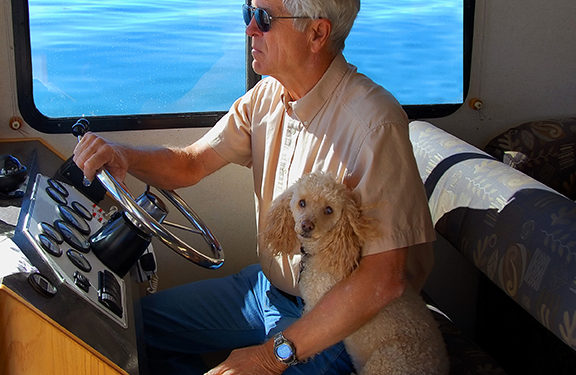 man and dog operate houseboats