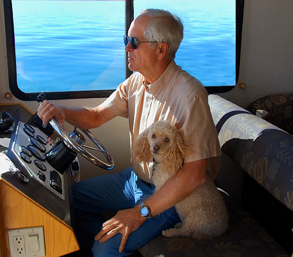 man and dog operate houseboats