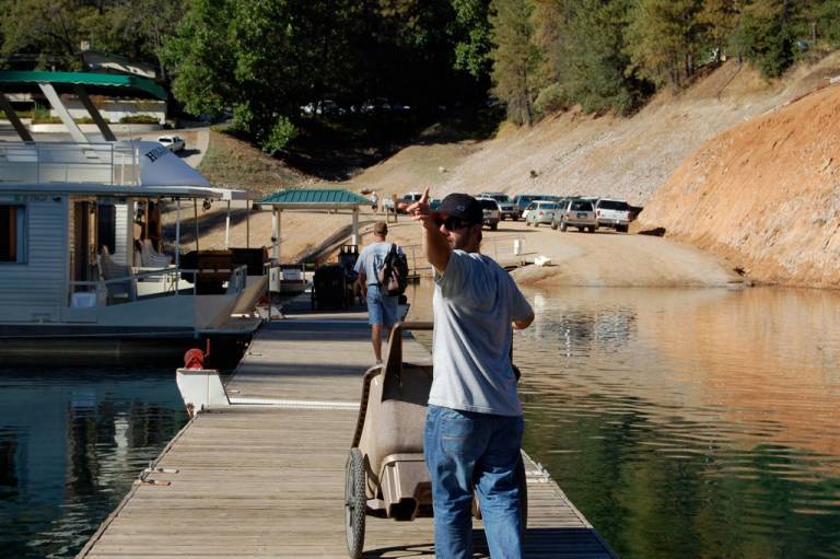 employee helps customers with houseboat rentals