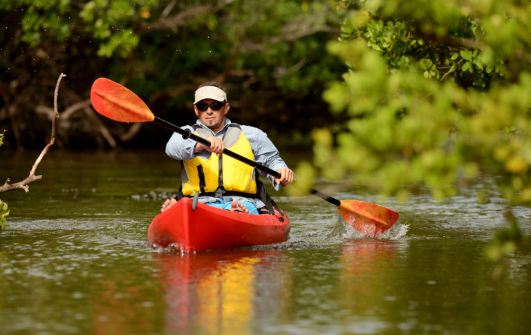 man paddling kayak during houseboat rentals