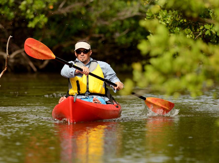 man paddling kayak during houseboat rentals
