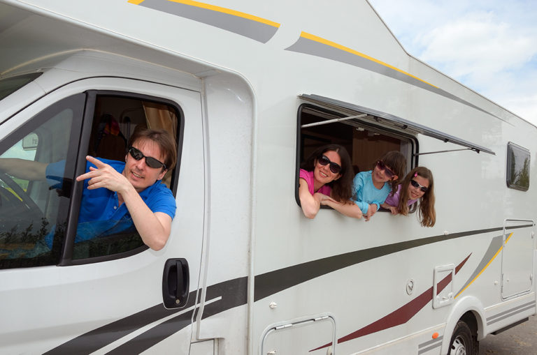 smiling family travels to rv campground