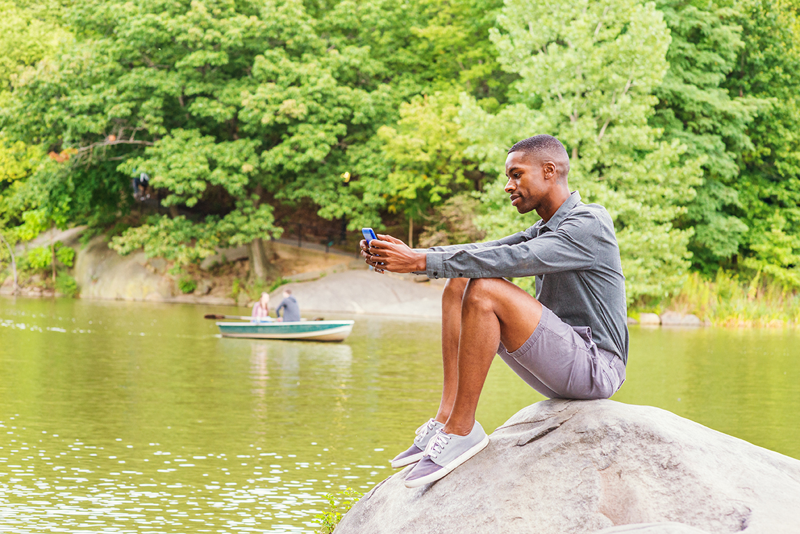 man waiting learning about houseboat rentals on tablet